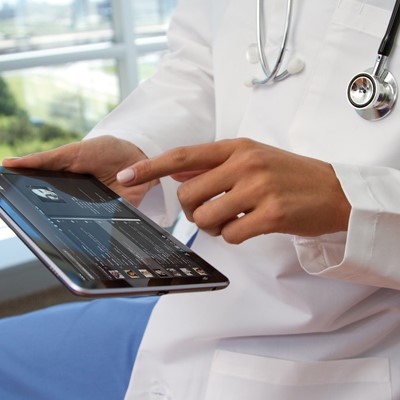 A doctor using a tablet computer to access patient records and medical information