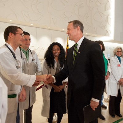 A group of doctors shaking hands in a hospital, symbolizing collaboration and teamwork in healthcare.