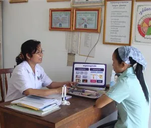 a woman sitting at a desk with a laptop computer